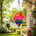 Rainbow chevron hot air balloon solar lantern hanging beside a flower-filled garden porch