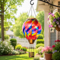Rainbow mosaic hot air balloon solar lantern hanging beside a sunny garden porch